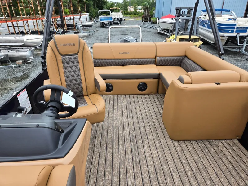 Slide: The Image of 2026 Harris Cruiser 210 boat interior with tan seating and wood-patterned flooring. - 14