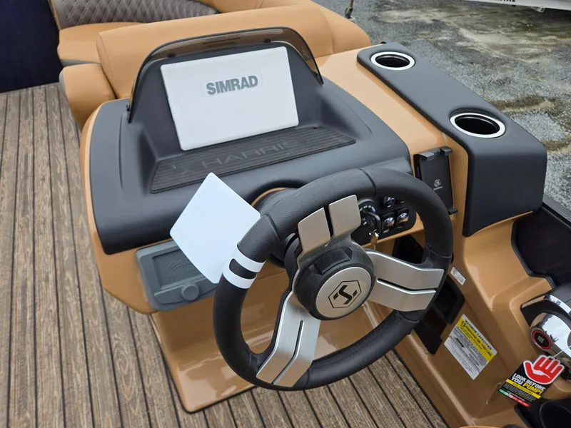 Slide: The Image of 2026 Harris Cruiser 210 boat dashboard with Simrad display and steering wheel. - 17