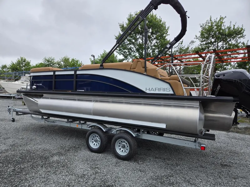 Slide: The Image of 2026 Harris Cruiser 210 pontoon boat on trailer, parked outdoors. - 2