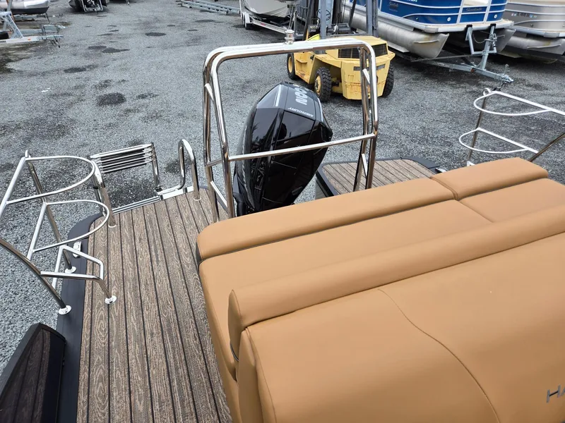 Slide: The Image of 2026 Harris Cruiser 210 boat with tan seating and outboard motor in a marina. - 24