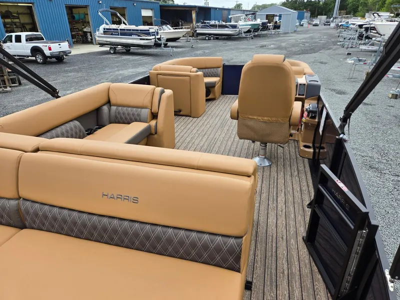 Slide: The Image of 2026 Harris Cruiser 210 pontoon boat with tan seating, docked at a marina. - 27