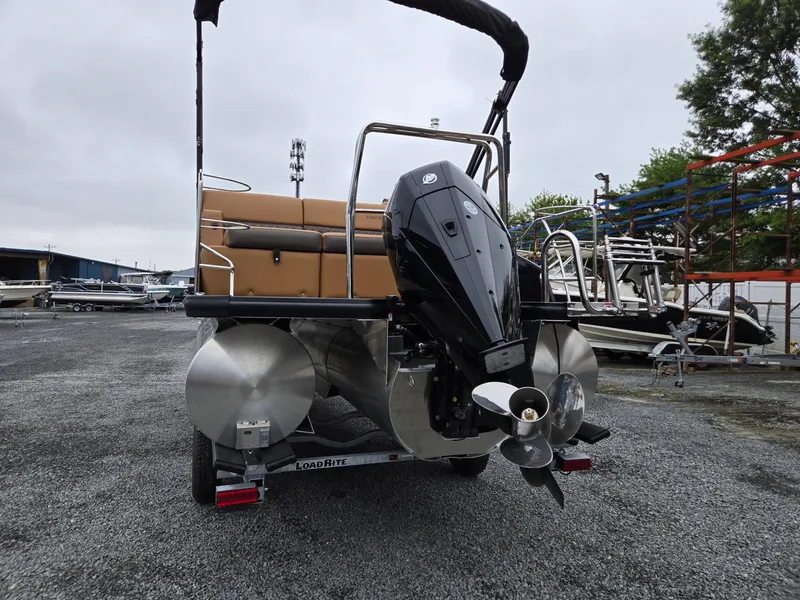 Slide: The Image of 2026 Harris Cruiser 210 pontoon boat with powerful outboard motor, parked on gravel. - 3