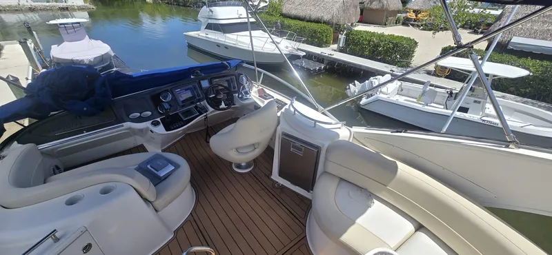 Slide: The Image of 2012 Meridian 341 Sedan yacht interior with helm, seating, and docked boats in marina. - 25