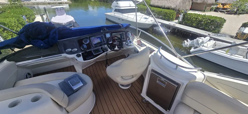 Slide: The Image of 2012 Meridian 341 Sedan yacht cockpit with modern controls and seating, docked near other boats. - 26