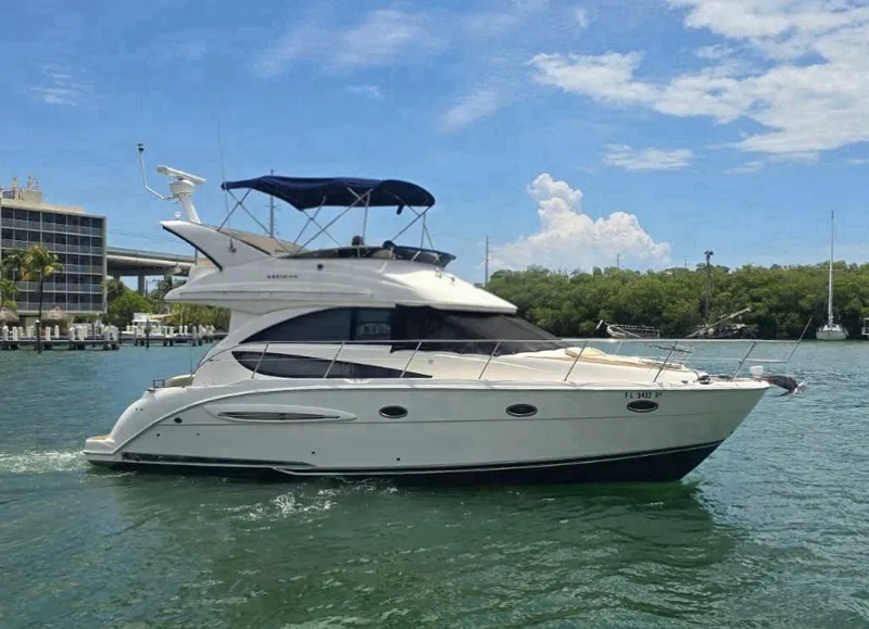 Slide: The Image of 2012 Meridian 341 Sedan yacht cruising on a sunny day, surrounded by lush greenery. - 33