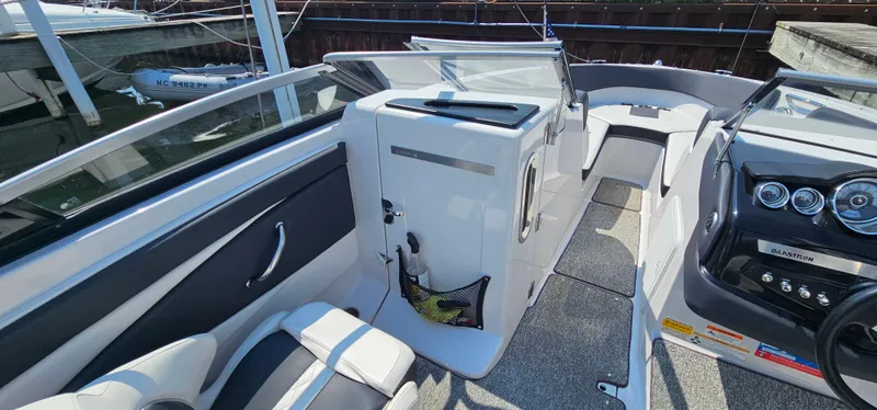 Slide: The Image of 2014 Glastron GT 245 boat interior with seating, dashboard, and storage compartment. - 10