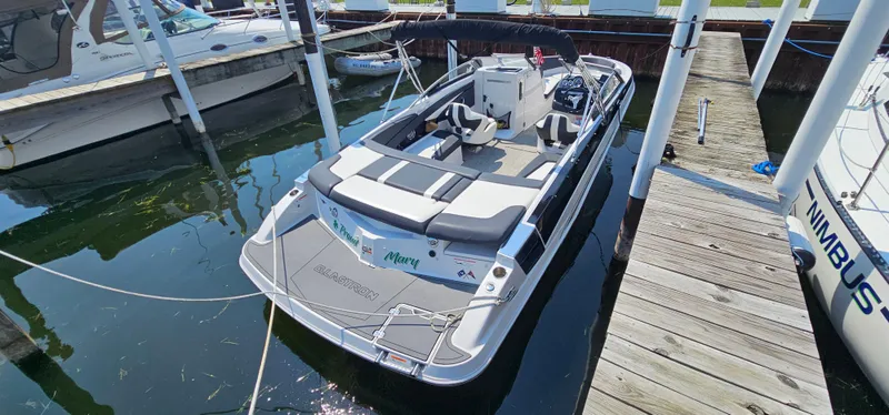 Slide: The Image of 2014 Glastron GT 245 boat docked in marina, featuring sleek design and spacious seating. - 21