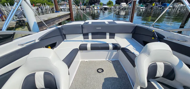 Slide: The Image of 2014 Glastron GT 245 boat interior with seating, docked at a marina. - 6