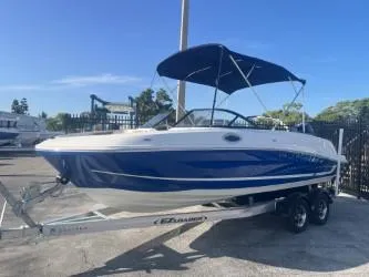 Slide: The Image of 2022 Bayliner VR6 boat with blue hull on a trailer, parked outdoors. - 1