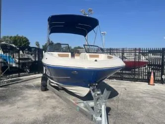 Slide: The Image of 2022 Bayliner VR6 boat on trailer, blue hull, parked outdoors. - 2