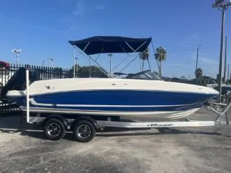Slide: The Image of 2022 Bayliner VR6 boat on trailer with blue canopy, parked outdoors. - 4