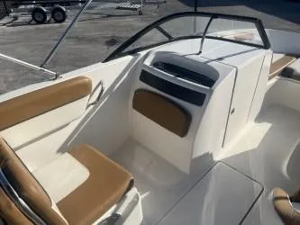 Slide: The Image of 2022 Bayliner VR6 boat interior with tan seating and sleek dashboard design. - 7