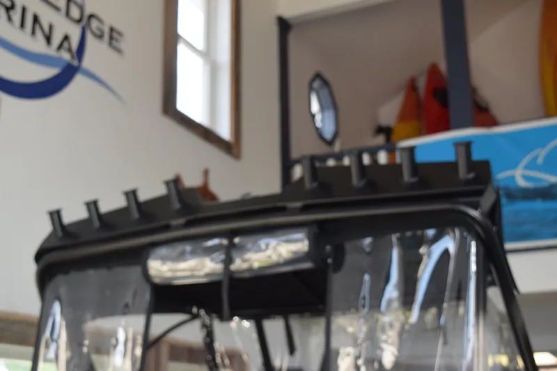 Slide: The Image of Blurry view of a 2026 Stabicraft 1550 Fisher Offshore boat in a marina showroom. - 15