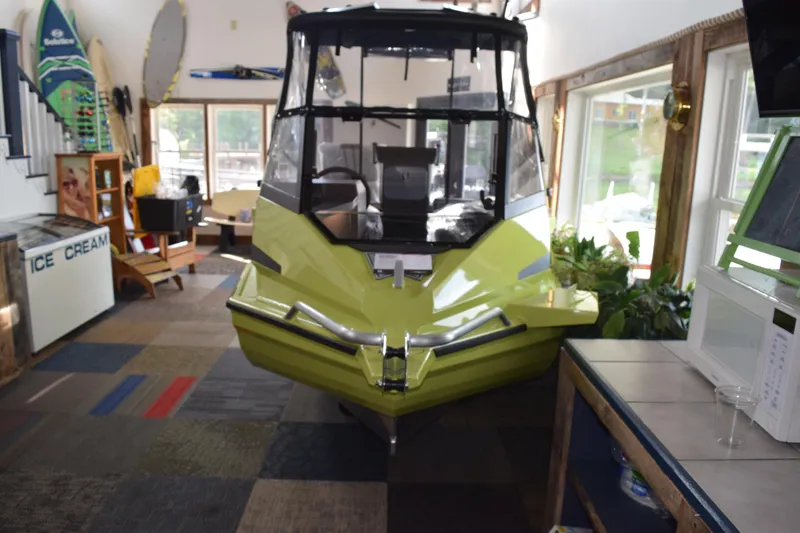 Slide: The Image of 2026 Stabicraft 1550 Fisher Offshore boat displayed indoors, surrounded by surfboards and decor. - 18
