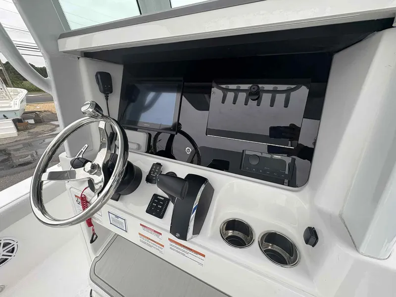 Slide: The Image of 2026 Blackfin 262 HB boat dashboard with steering wheel and electronic controls. - 12