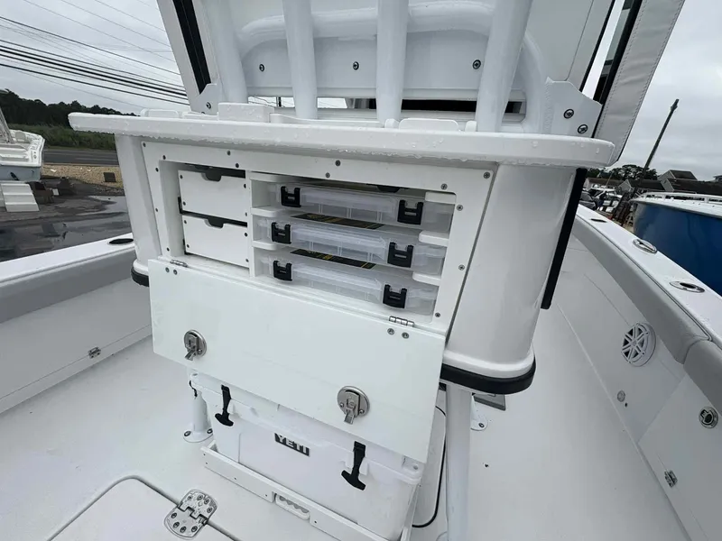 Slide: The Image of 2026 Blackfin 262 HB boat storage compartments with tackle boxes and cooler on deck. - 13