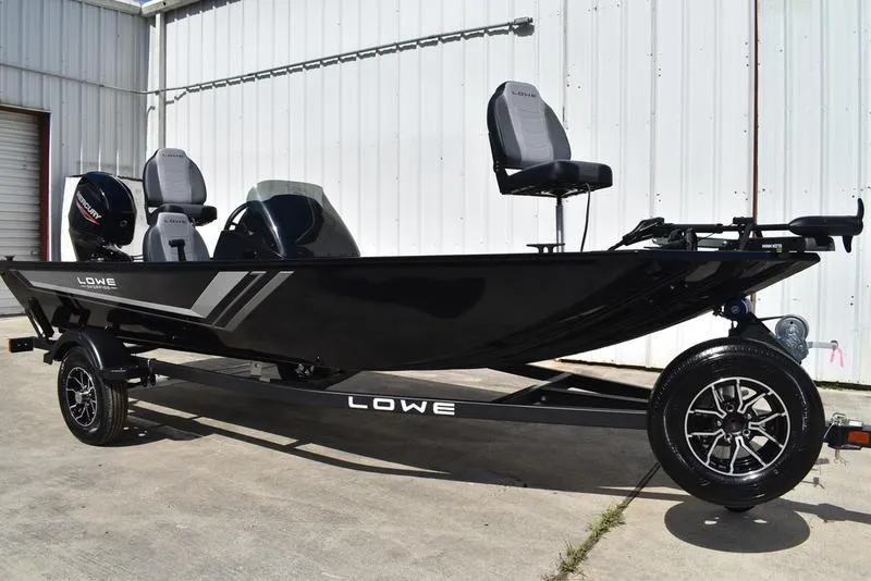 Slide: The Image of 2026 Lowe Skorpion 17 boat on trailer, sleek black design, parked outdoors. - 1