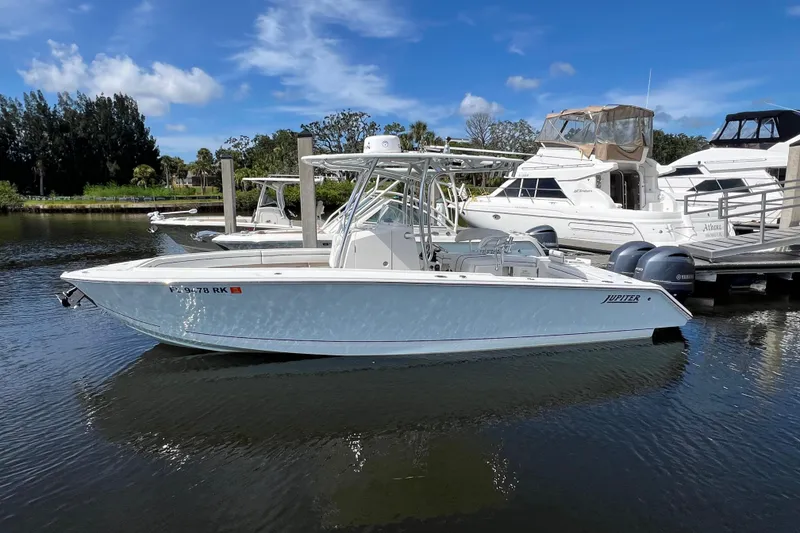 The Image of 2015 Jupiter 26 FS boat docked in a marina, clear sky, calm water. - 0