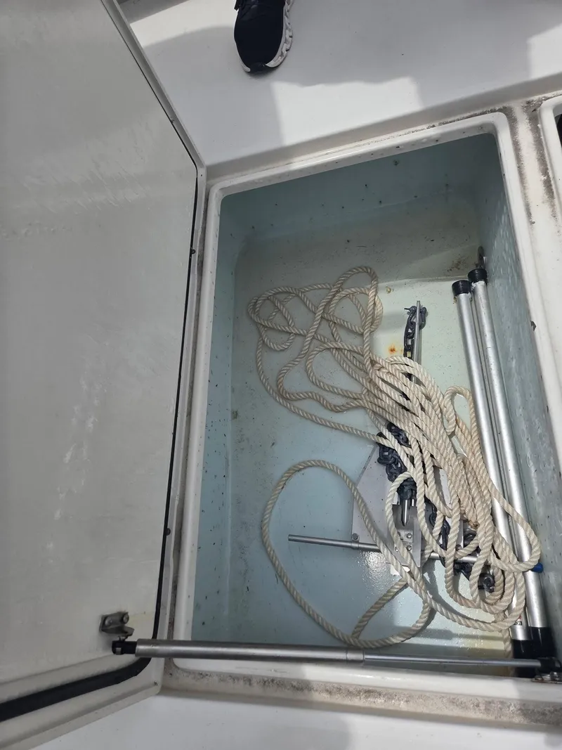 Slide: The Image of Open storage compartment on 2015 Jupiter 26 FS boat with rope and equipment. - 13