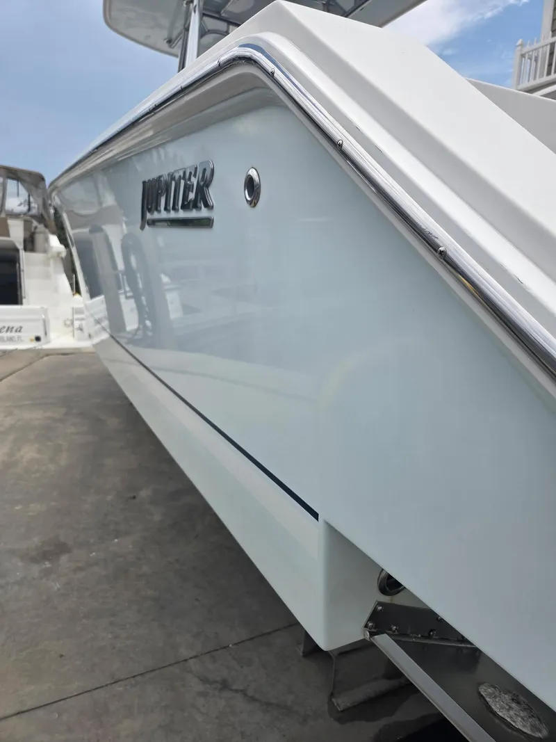 Slide: The Image of 2015 Jupiter 26 FS boat side view with sleek design and chrome detailing. - 2
