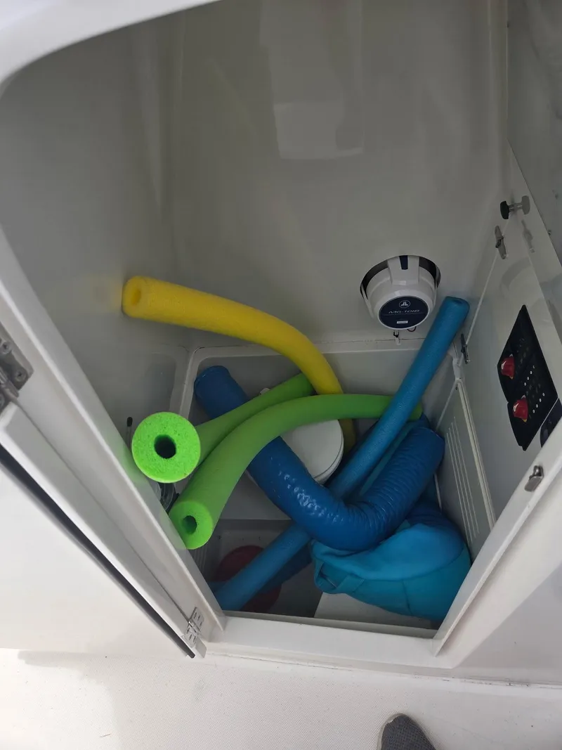 Slide: The Image of Storage compartment on 2015 Jupiter 26 FS boat with colorful pool noodles. - 22