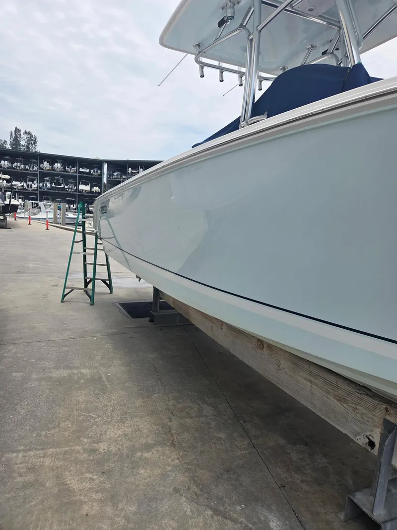 Slide: The Image of 2015 Jupiter 26 FS boat on dry dock, marina background, clear sky. - 24