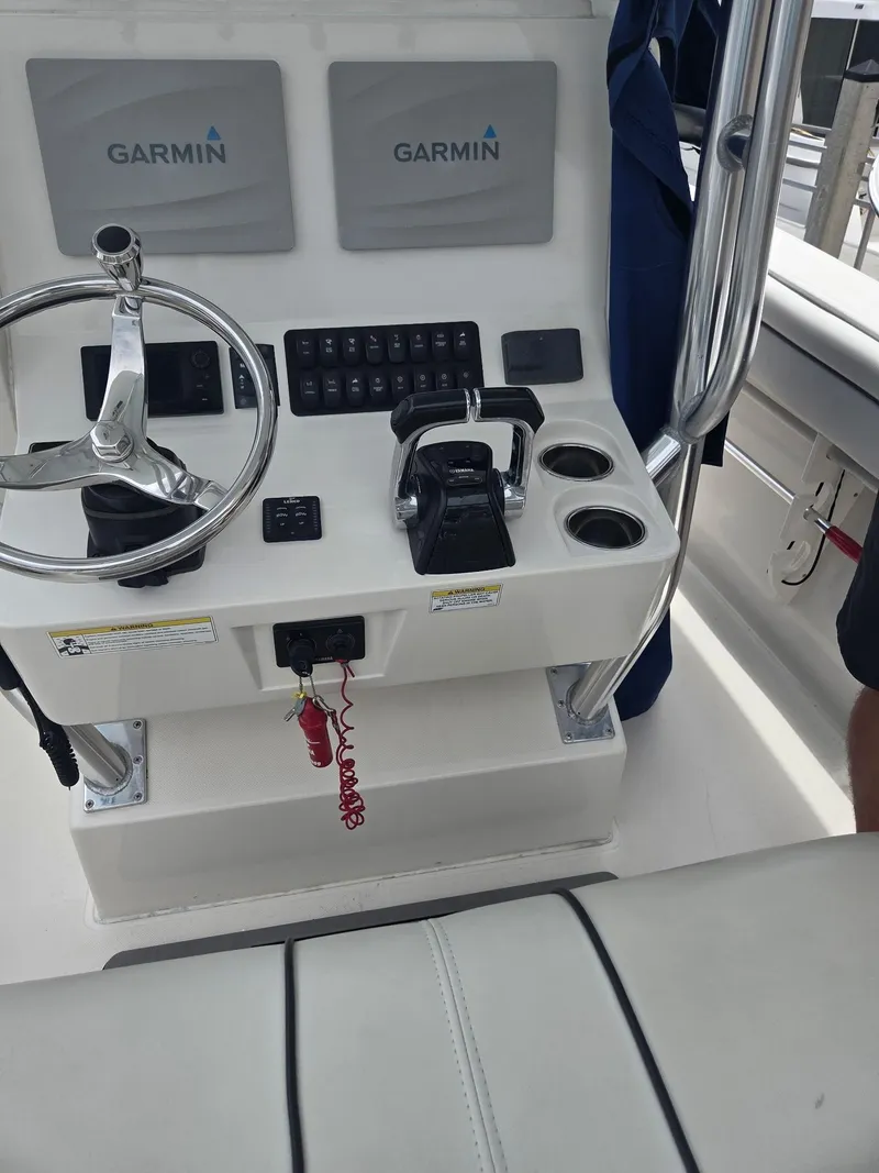 Slide: The Image of Control panel of a 2015 Jupiter 26 FS boat with Garmin displays and steering wheel. - 26