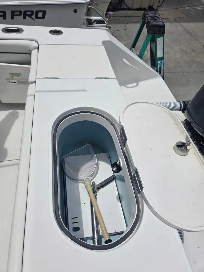 Slide: The Image of Open storage compartment on a 2015 Jupiter 26 FS boat with a net inside. - 27