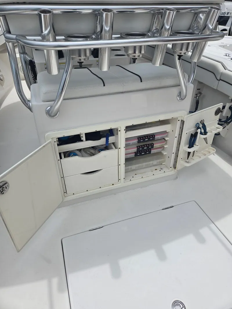 Slide: The Image of 2015 Jupiter 26 FS boat interior with open storage compartments and rod holders. - 3