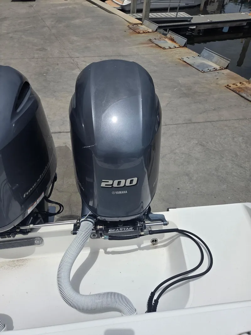 Slide: The Image of Yamaha 200 outboard motor on a 2015 Jupiter 26 FS boat at a dock. - 32