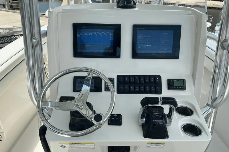 Slide: The Image of Control panel of a 2015 Jupiter 26 FS boat with steering wheel and digital displays. - 35