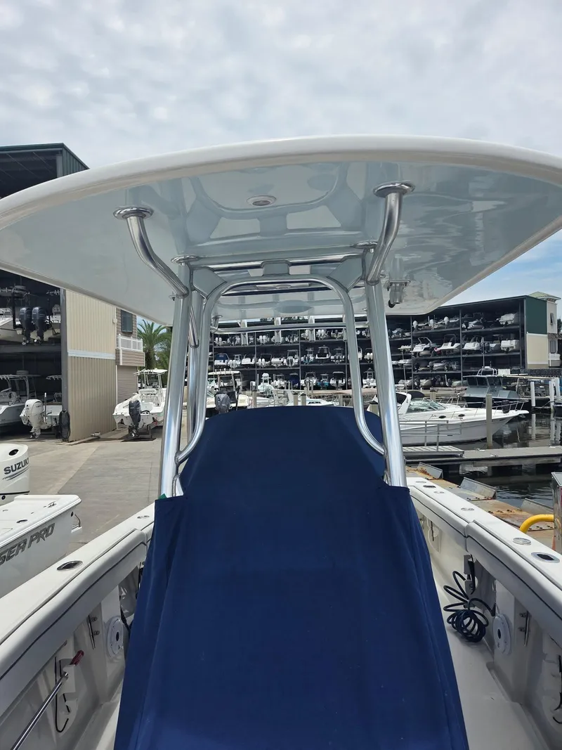 Slide: The Image of 2015 Jupiter 26 FS boat with T-top, docked at marina with multiple boats. - 5