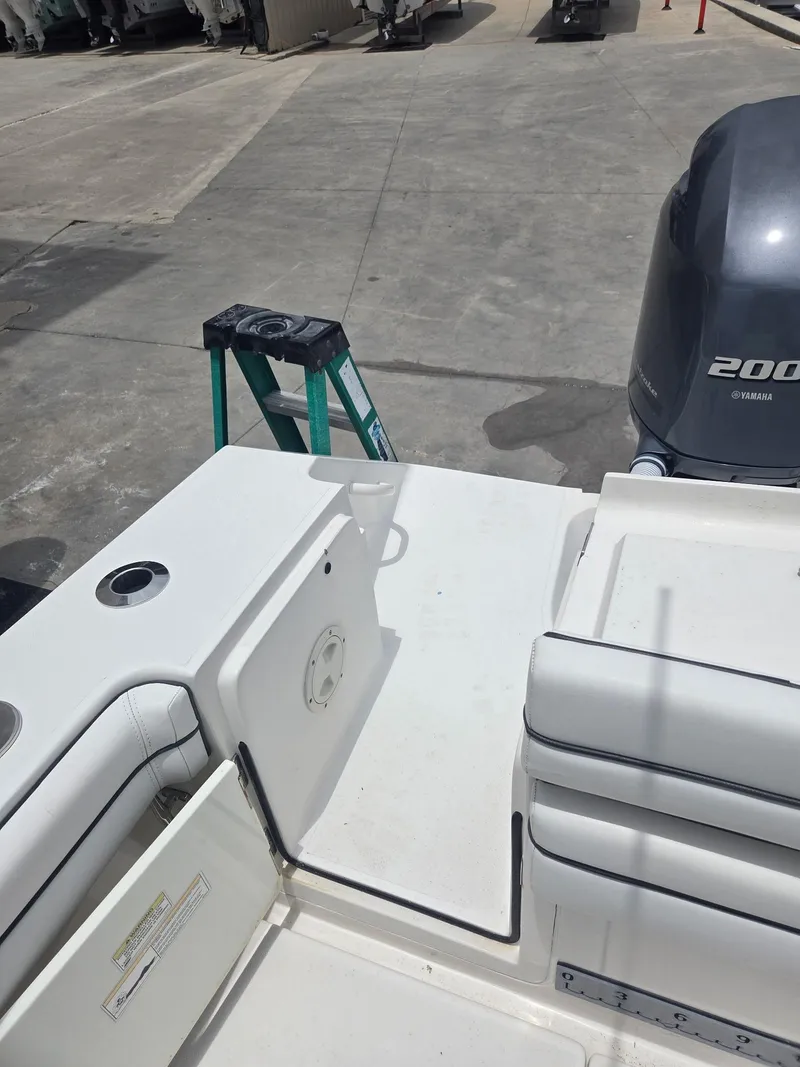 Slide: The Image of 2015 Jupiter 26 FS boat deck with Yamaha 200 engine in a marina setting. - 6