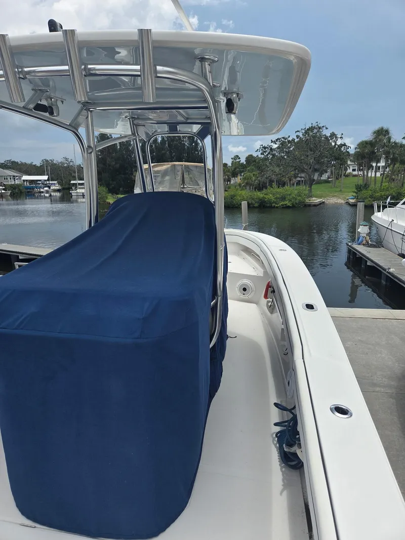 Slide: The Image of 2015 Jupiter 26 FS boat with blue cover docked by a scenic waterfront. - 8