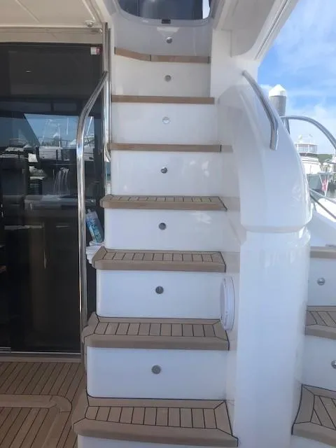 Slide: The Image of Staircase on 2016 Princess 52 Flybridge Yacht with teak steps and stainless steel railing. - 10