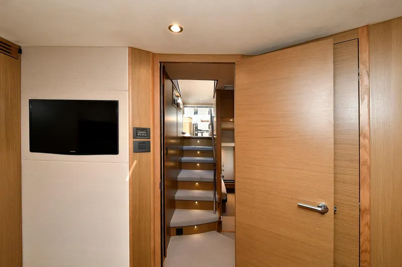 Slide: The Image of Interior of 2016 Princess 52 Flybridge Yacht with wooden stairs and wall-mounted TV. - 26