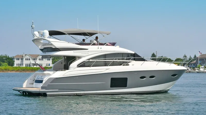 Slide: The Image of 2016 Princess 52 Flybridge Yacht cruising on calm waters near residential area. - 4