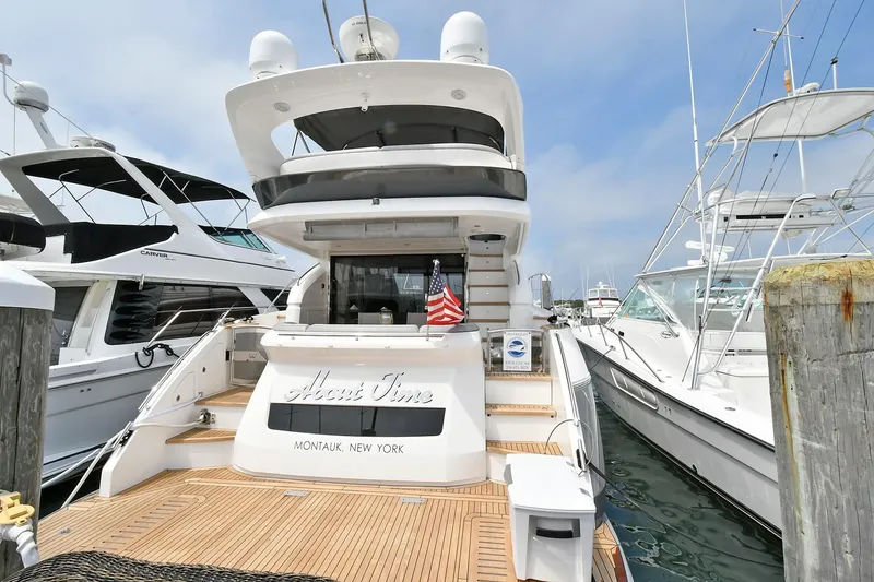 Slide: The Image of 2016 Princess 52 Flybridge Yacht docked, featuring spacious deck and American flag. - 7