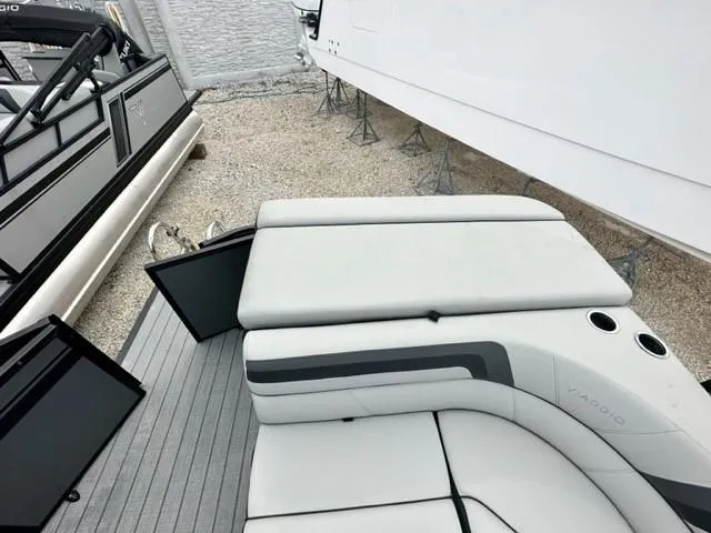Slide: The Image of 2023 Viaggio Lago C boat interior with gray seating and cup holders, displayed outdoors. - 6