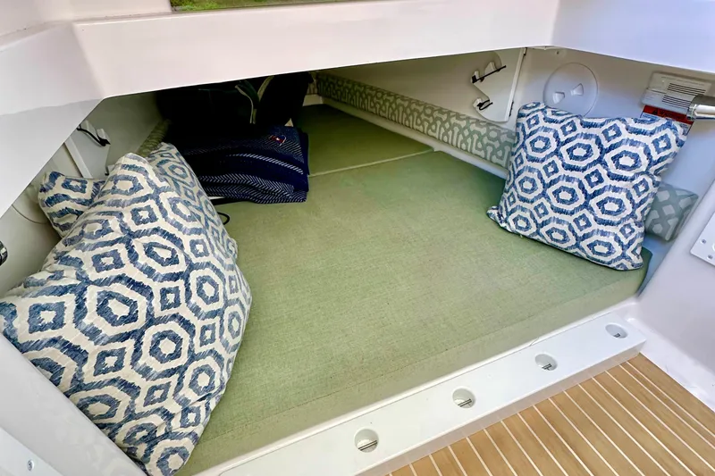 Slide: The Image of 2021 Regulator 34SS cabin interior with patterned cushions and green bedding. - 27
