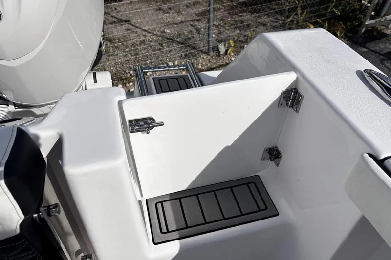 Slide: The Image of 2026 Tidewater 256 CC Adventure boat, open storage compartment with stainless steel hinges. - 12