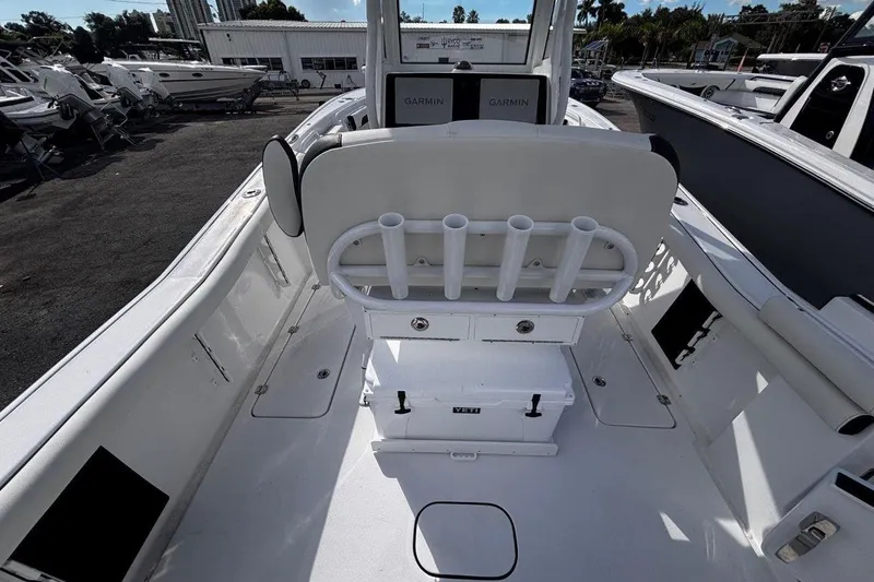 Slide: The Image of 2026 Tidewater 256 CC Adventure boat interior with rod holders and Garmin electronics. - 18