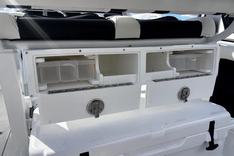 Slide: The Image of 2026 Tidewater 256 CC Adventure boat storage compartments with secure latches and organized interior. - 19