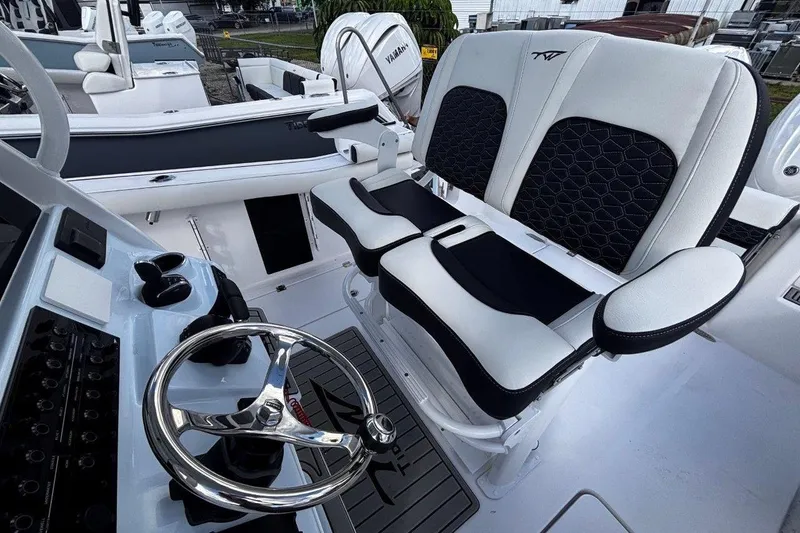 Slide: The Image of 2026 Tidewater 256 CC Adventure boat interior with dual seats and steering wheel. - 20