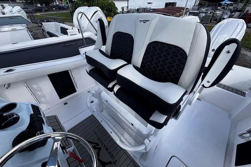 Slide: The Image of 2026 Tidewater 256 CC Adventure boat with dual cushioned seats and steering wheel. - 21