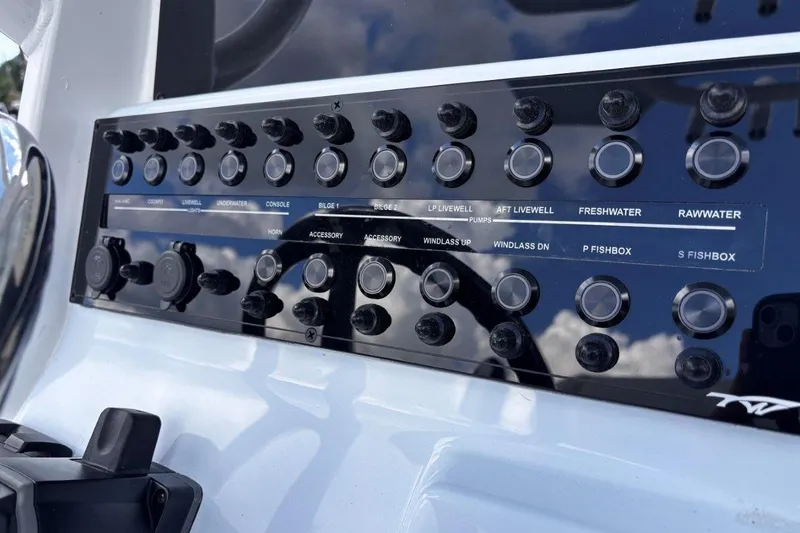 Slide: The Image of Control panel of 2026 Tidewater 256 CC Adventure boat with various switches and buttons. - 23