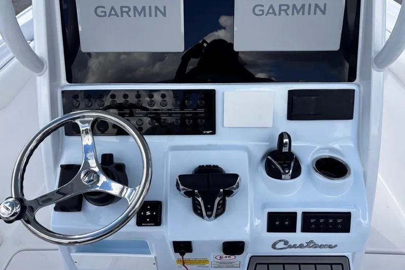 Slide: The Image of Control panel of 2026 Tidewater 256 CC Adventure boat with Garmin displays and steering wheel. - 24