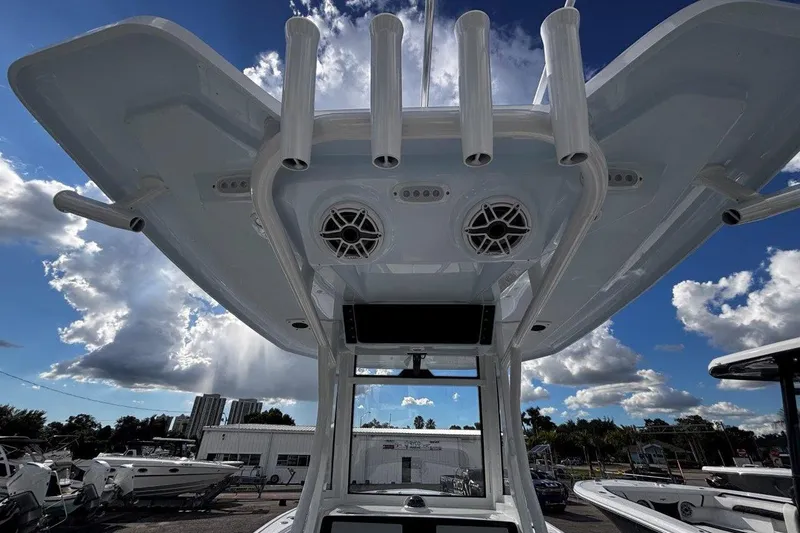 Slide: The Image of 2026 Tidewater 256 CC Adventure boat, view of T-top with rod holders and speakers. - 26