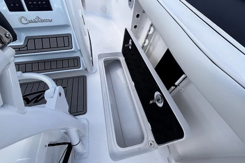 Slide: The Image of 2026 Tidewater 256 CC Adventure boat interior with storage compartment and custom flooring. - 36
