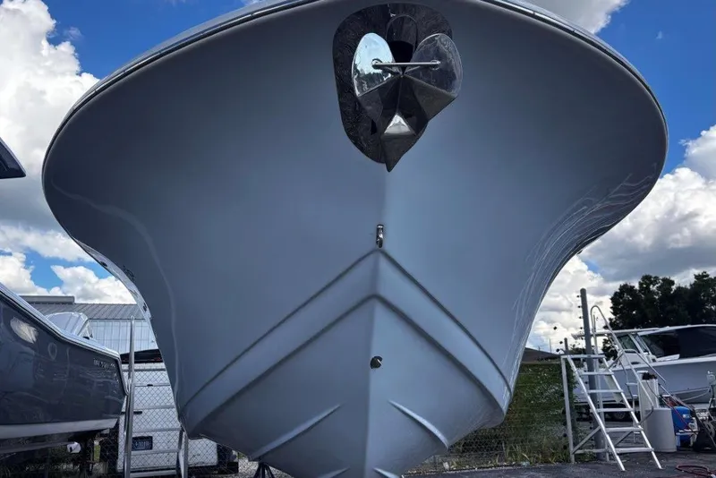 Slide: The Image of 2026 Tidewater 256 CC Adventure boat, front view, showcasing sleek hull design under a blue sky. - 4